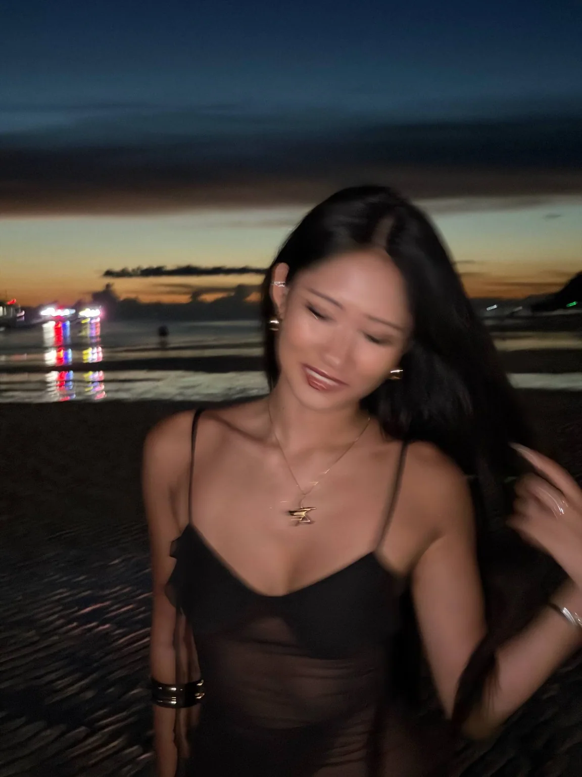 Vera in a black outfit at the beach